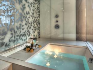 a bathroom with a bath tub in a room at Seehotel Waldstätterhof Swiss Quality in Brunnen