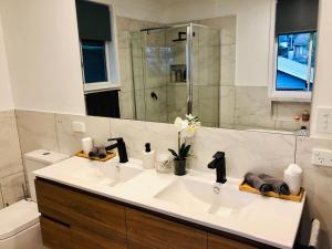 a bathroom with a white sink and a shower at Bellbird House in Cessnock