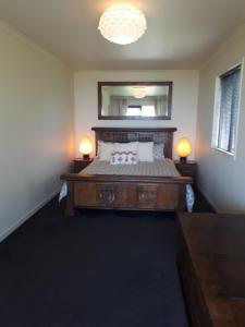 1 dormitorio con 1 cama con espejo y 2 lámparas en Beach front cottage, en Charleston