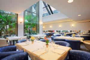 a restaurant with tables and chairs and large windows at Turin City Centre in Turin