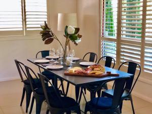 a dining room with a blue table and chairs at Bellbird House in Cessnock