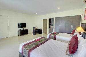 a hotel room with two beds and a television at Nila Beach Resort in Lautoka