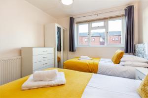 - une chambre avec 2 lits et une fenêtre dans l'établissement 4 Bedrooms Cosy Family Home, Super-Fast Wi-Fi, Free Parking, The Saddlers Gateway, à Walsall