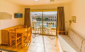 a dining room with a table and chairs and a balcony at Apartamentos Charco del Conde in Valle Gran Rey