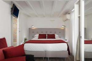 um quarto com uma cama grande e um sofá vermelho em Hotel Navona em Roma