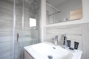 a white bathroom with a sink and a shower at B&B EL DUCHE in Empoli