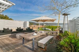 un patio con mesa y sombrilla en TH40 Thesen Islands en Knysna