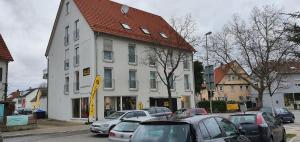 a large white building with cars parked in front of it at Outletcity Ferienwohnung Wohnung 1 in Metzingen