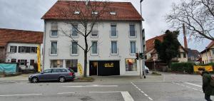 a blue car parked in front of a white building at Outletcity Ferienwohnung Wohnung 1 in Metzingen
