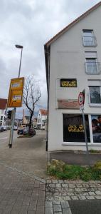 a white building with a sign in front of it at Outletcity Ferienwohnung Wohnung 1 in Metzingen