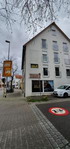a white building with a car parked in front of it at Outletcity Ferienwohnung Wohnung 1 in Metzingen +25 photos