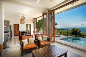 a living room with a pool and a table and chairs at Philip's Villa in Ko Tao
