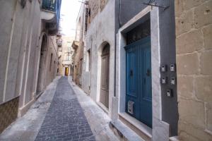 Une allée avec une porte bleue dans un bâtiment dans l'établissement St George of Lydda B&B, à Victoria