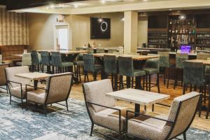 a restaurant with tables and chairs and a bar at Holiday Inn Riverton-Convention Center, an IHG Hotel in Riverton