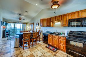 a kitchen with wooden cabinets and a table and chairs at Bayview Beach Escape in Pensacola Beach