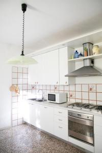 kuchnia z białymi szafkami i piekarnikiem w obiekcie IseoLakeRental - Casa La Rondine w mieście Predore