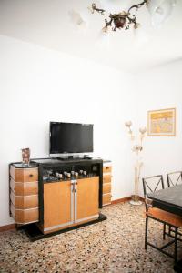 salon z telewizorem z płaskim ekranem i stołem w obiekcie IseoLakeRental - Casa La Rondine w mieście Predore