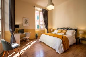 a bedroom with a bed and a desk and a window at Family Apartments Angeli in Genoa