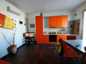 a kitchen with orange cabinets and a tv in it at Fata Morgana in Casamassella +37 photos
