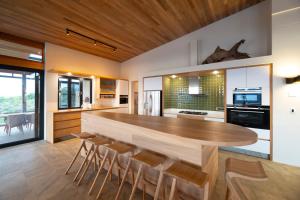 una cucina con un grande tavolo in legno e sedie di Alkira Lodge a Brenton-on-Sea
