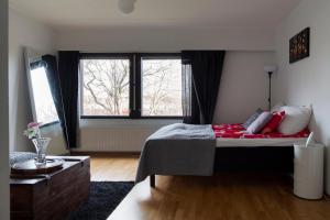 a bedroom with a bed and a large window at 2ndhomes Katajanokka Apartment with Seaview and Sauna in Helsinki