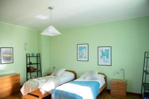 2 łóżka w pokoju z zielonymi ścianami w obiekcie IseoLakeRental - Casa La Rondine w mieście Predore +32 zdjęcia
