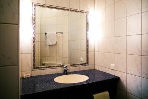 La salle de bains est pourvue d'un lavabo et d'un miroir. dans l'établissement Gasthof Hotel Lang, à Rauchwart im Burgenland