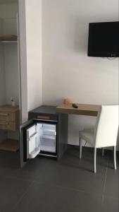 Zimmer mit einem Schreibtisch, einem Stuhl und einem TV in der Unterkunft I Due Scogli in Rocca Imperiale