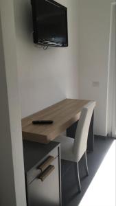 einen Schreibtisch mit Stuhl und einen TV an der Wand in der Unterkunft I Due Scogli in Rocca Imperiale
