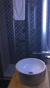 ein Badezimmer mit einem weißen Waschbecken und einer Dusche in der Unterkunft I Due Scogli in Rocca Imperiale