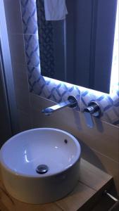 ein Badezimmer mit einem weißen Waschbecken und einem Spiegel in der Unterkunft I Due Scogli in Rocca Imperiale