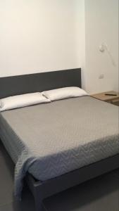 Bett mit schwarzem Kopfteil und weißer Bettwäsche in der Unterkunft I Due Scogli in Rocca Imperiale