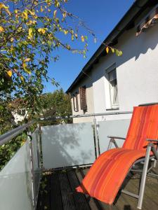 een oranje stoel op het balkon van een huis bij 2 Zimmer Wohnung mit Balkon - Nähe Messe in Haar