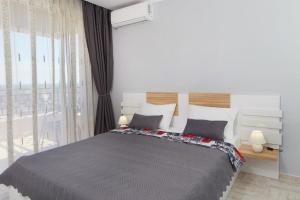 een slaapkamer met een groot bed en een groot raam bij Niko's Sea View Apartments Deluxe in Nesebar