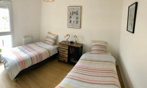 a bedroom with two beds and a dresser in it at happiness Disney in Saint-Germain-sur-Morin