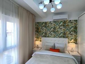 a bedroom with a white bed with a floral wall at Plaza Madrid Central in Madrid