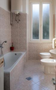 a bathroom with a tub and a toilet and a sink at Apartman Sandra in Pula