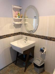 a bathroom with a sink and a mirror and a toilet at Krabilife Resort in Klong Muang Beach