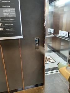 una puerta de metal con un cartel en la pared en The Mains Hotel, en Cheonan