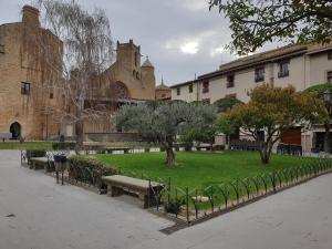 a park with benches and trees and a building at B&B La Atalaya in Olite