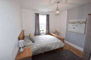 a bedroom with a bed and a window at Drift Away Apartment in Westward Ho