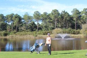 a woman standing next to a baby stroller in front of a pond at LES CHAMBRES DU HOURON in Moliets-et-Maa