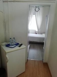 Habitación blanca pequeña con cama en Pensao Residencial Estrela do Mondego, en Lisboa
