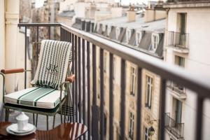uma cadeira sentada na varanda de um edifício em J.K. Place Paris em Paris