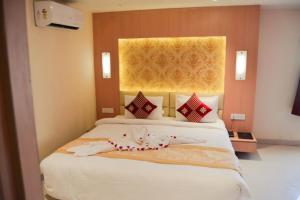 a bedroom with a bed with white sheets and a window at THE RED VELVET HOTEL in Patna