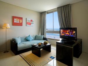 a living room with a couch and a flat screen tv at Atlas Essaouira & Spa in Essaouira