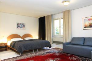 - une chambre avec un lit et un canapé bleu dans l'établissement Swedish Village Hotel, à Timachiovsk