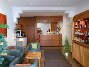 a woman is standing in a waiting room at Hotel Gerberhof in Backnang