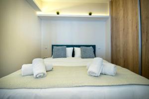 ein Schlafzimmer mit einem Bett mit weißen Handtüchern darauf in der Unterkunft Abstract Flat With Urban View in Athen