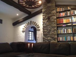 a living room with a couch and a book shelf with books at L'abri la Vall in Sorède